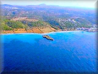 Vist aerea de la urbanizacion de Santo tomas a la derecha de la panoramica y las playas de Binigaus al final de las tierras de cultivo