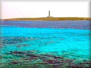 Faro de la Isla del Aire, su aislamiento ha provocado una especie de lagartijas negras unicas en Baleares se encuentra frente a la Playa de Punta prima y se hacen excurciones en barco