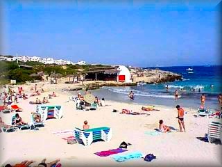 La ermosa playa de binibeca, es y a sido uno de los emblemas para el reclamo turistico de la isla de Menorca dispone de tods los sevicios de plata y un boeque de pinos al fondo de la playa