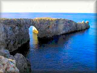 Blick auf das unberührte Gebiet von Pont d'en Gil (Brücke von Gil), ein Steinbogen, der durch die Erosion des Meeres in den Felsen der Küste ganz im Westen von Menorca entstanden ist.